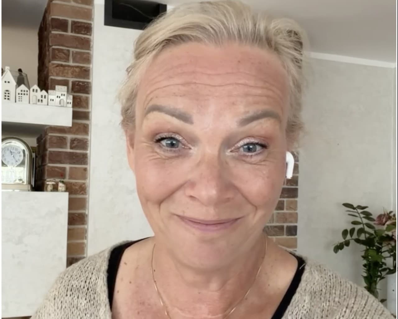 Jarka Matušková se dívá do objektivu a lehce se usmívá, doma u cihlové stěny.